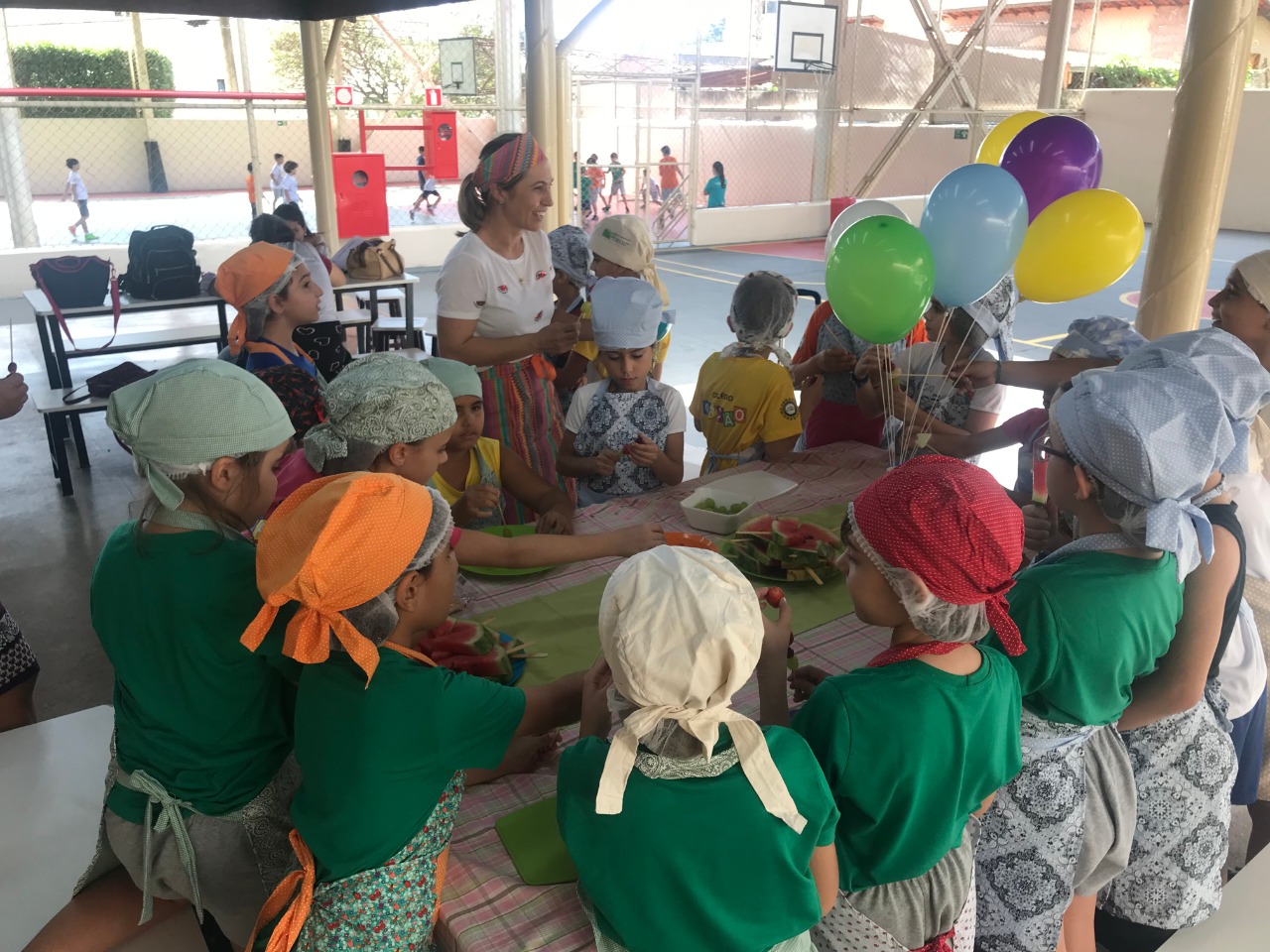 Oficina de culinária com crianças preparando alimentos