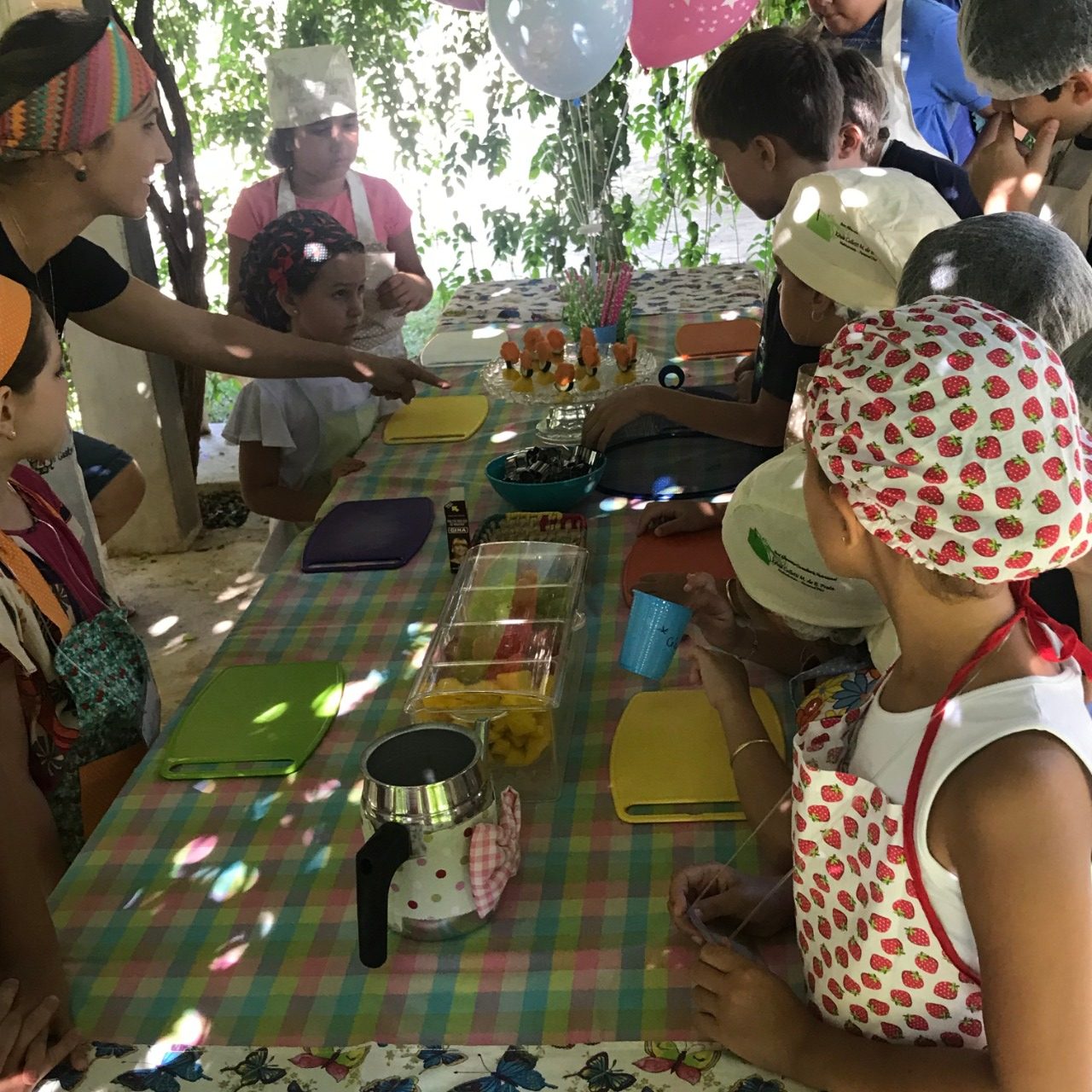 Kézia orientando crianças em oficina de culinária