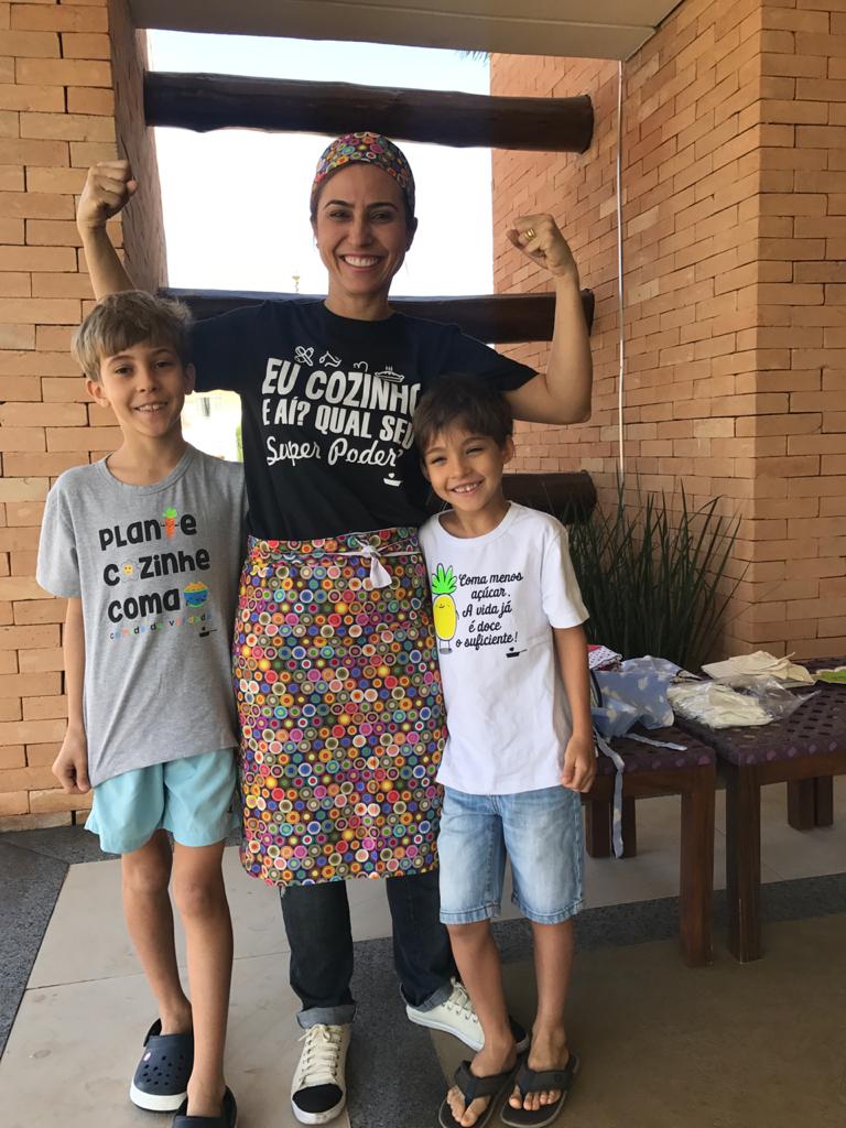 Kézia com duas crianças após oficina